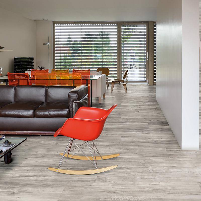 Ash wood-look porcelain tile flooring in modern living room interior with leather sofa and red rocking chair