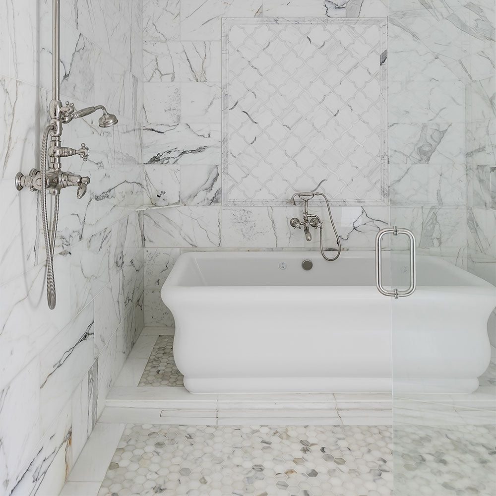 Elegant Calacatta marble tiles showcasing unique gray and gold veining against a striking white background, embodying sophistication and luxury in interior design.