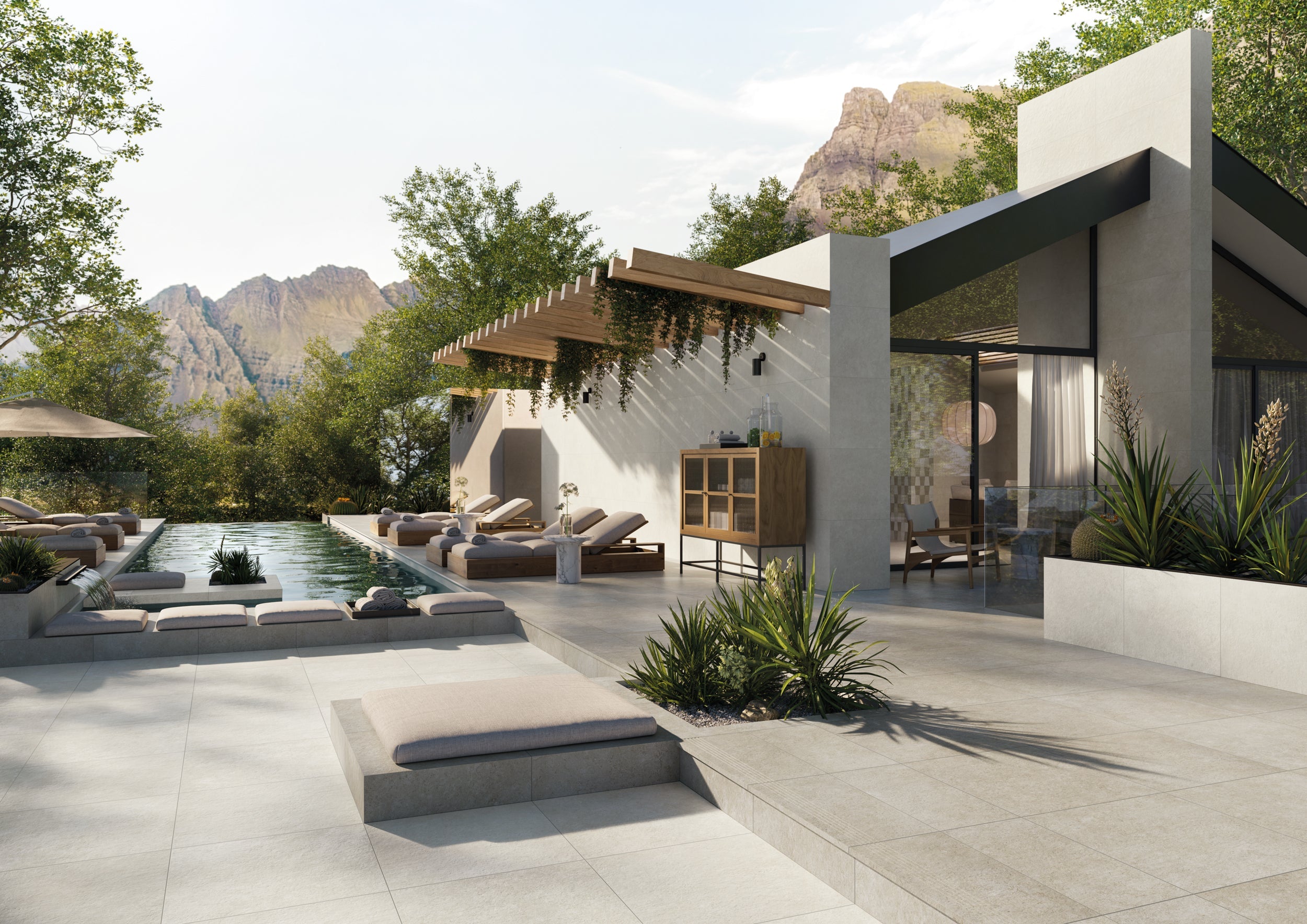 Luxury outdoor porcelain tile collection by Surface Group featuring modern patio design with pool, lounge chairs, and mountain view.