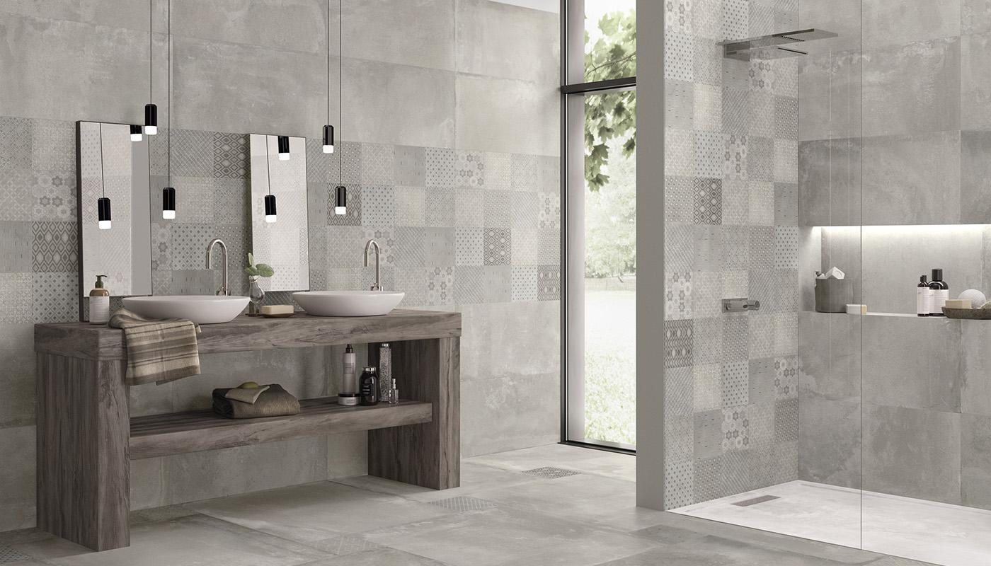 Emilceramica Kotto Italian porcelain tile collection in a modern bathroom setting with double vessel sinks, wall-mounted faucets, and decorative mosaic tile accents.