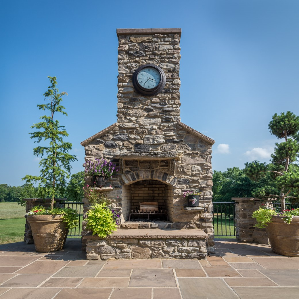 wall veneer faux stone outdoor fireplace with clock on the chimney
