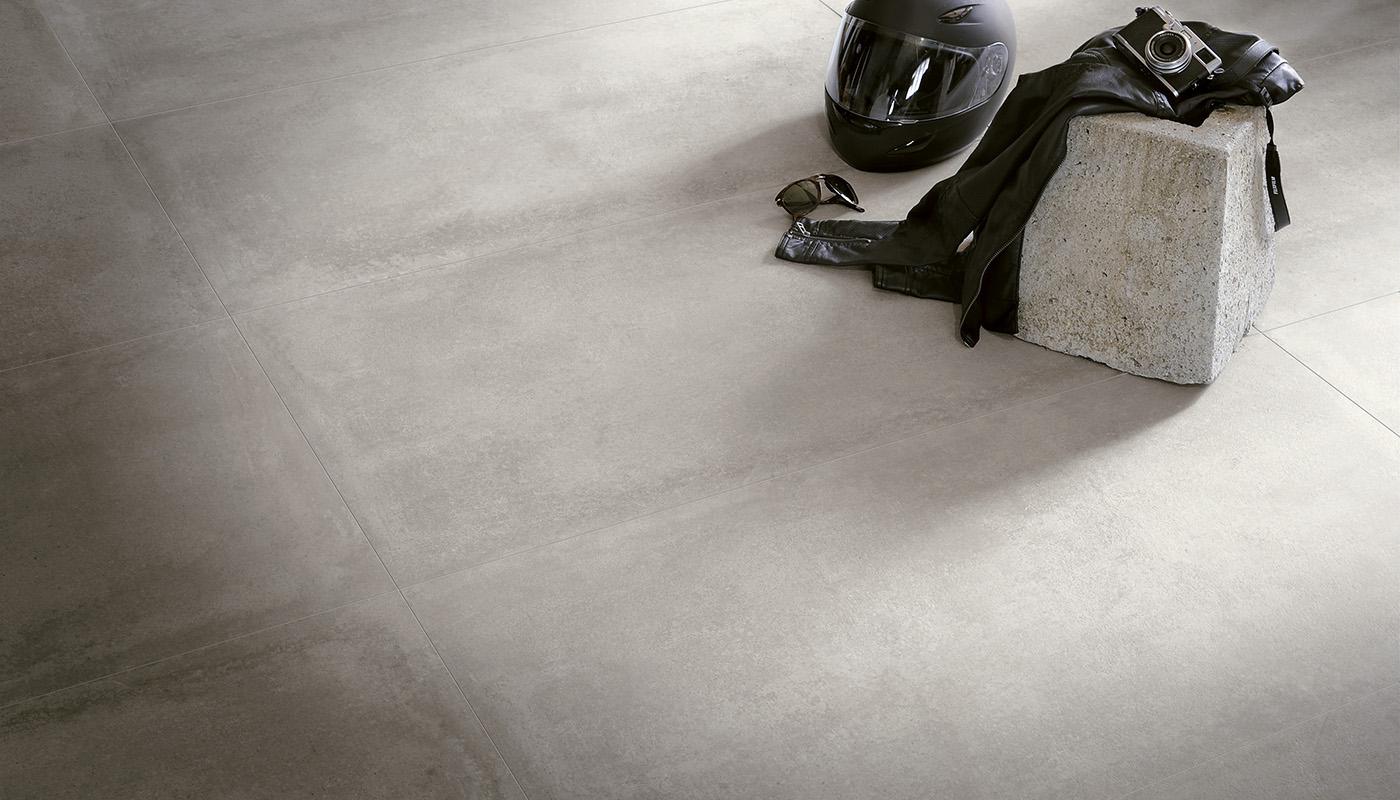 Modern porcelain tile flooring from Emil Viva Nr21 collection with motorcycle helmet, gloves, and jacket accessories for a stylish interior design concept.
