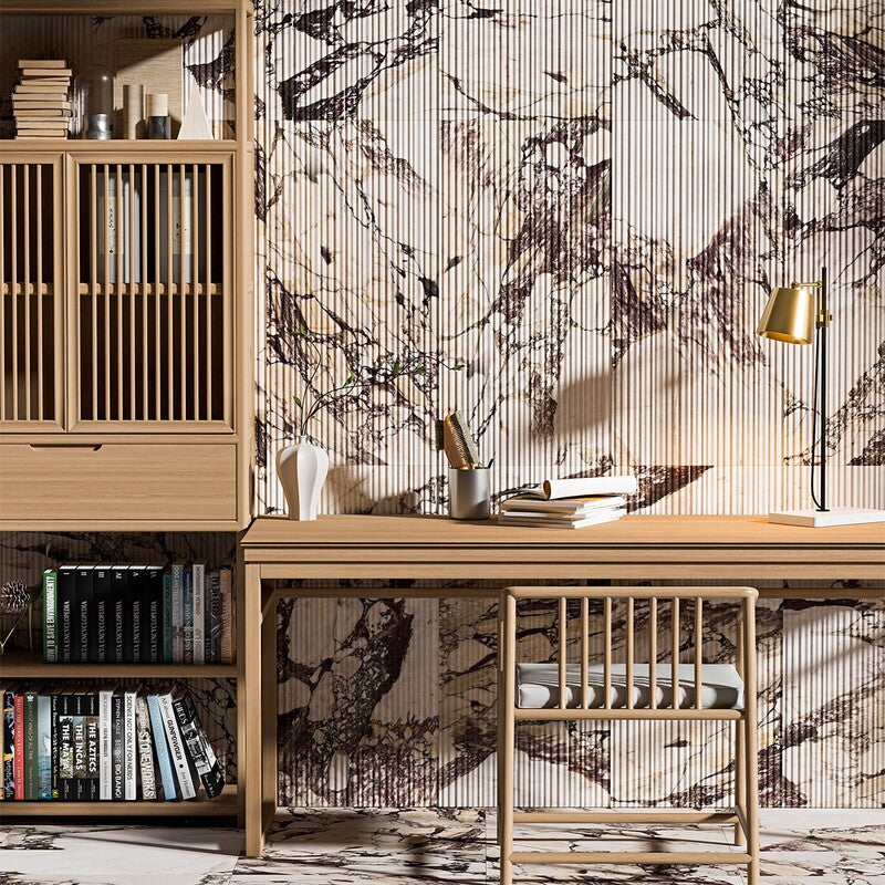 Modern home office with light wood furniture, bookshelves, and cabinets. Wall and floor with Calacatta Viola marble tiles, well-lit with natural light.
