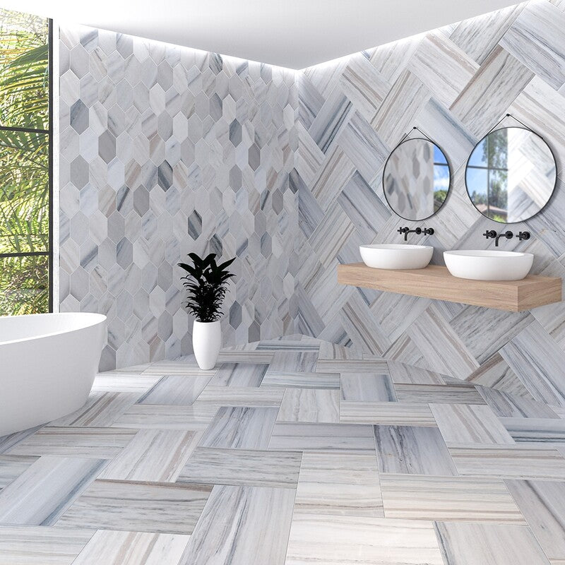 Modern bathroom with gray marble tiles, freestanding bathtub, floating vanity, round mirrors, potted plant, large window.