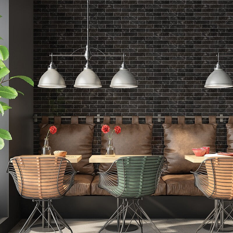 Modern café with black tile backsplash, leather benches, wireframe chairs, red flowers, industrial pendant lights, and a touch of greenery.