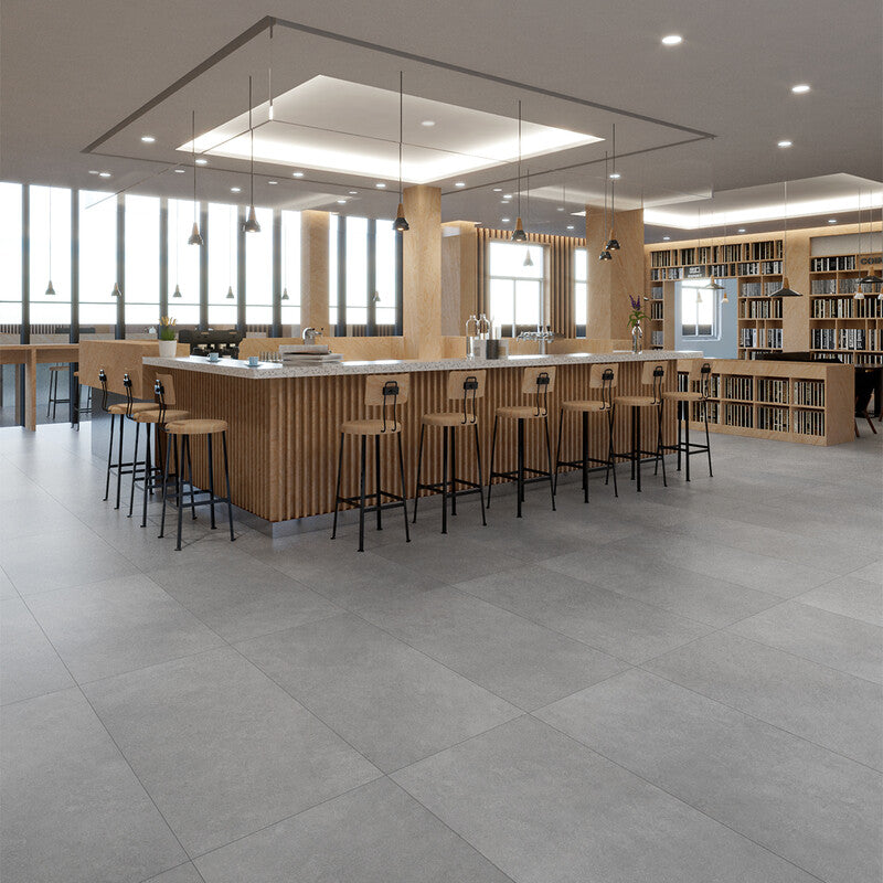 Modern interior with gray floor tiles, wooden island, bar stools, pendant lighting, bookshelves.