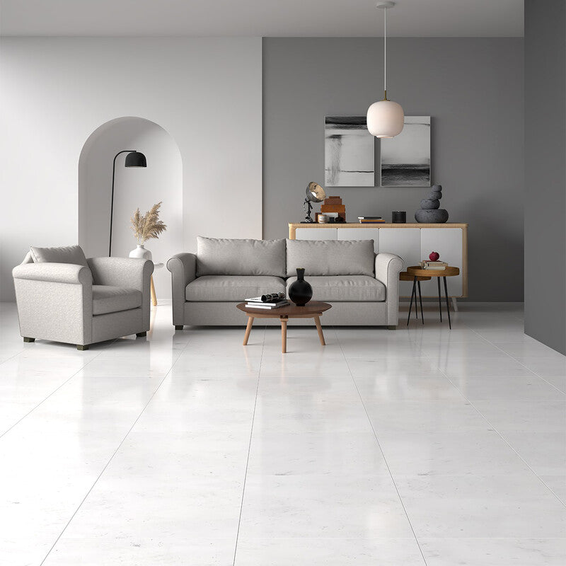 Modern living room with polished white marble floor tiles, gray sofa and armchair, wooden coffee table, white and wood sideboard, minimalist light fixture.