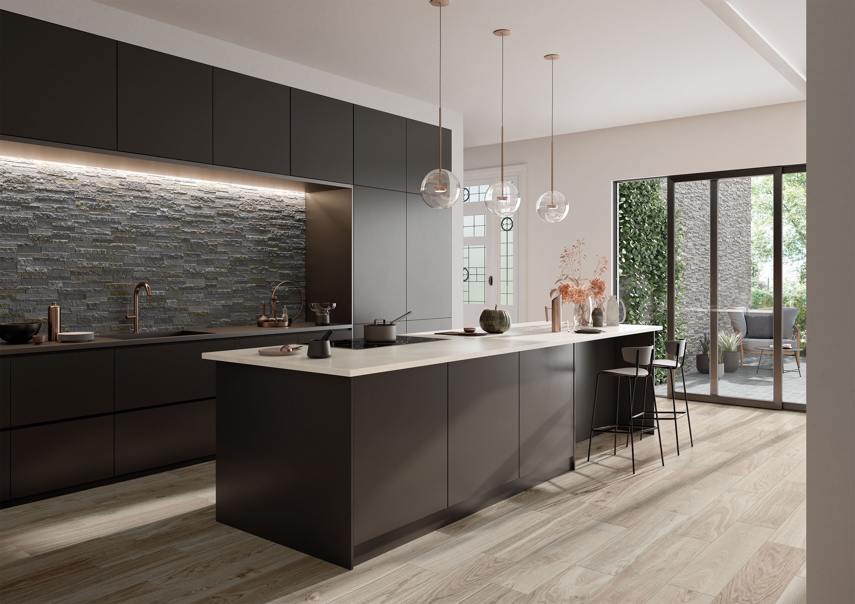 Modern kitchen with bluestone ledgestone porcelain tile backsplash from Surface Group's Pro Collection, featuring sleek cabinetry and pendant lighting.