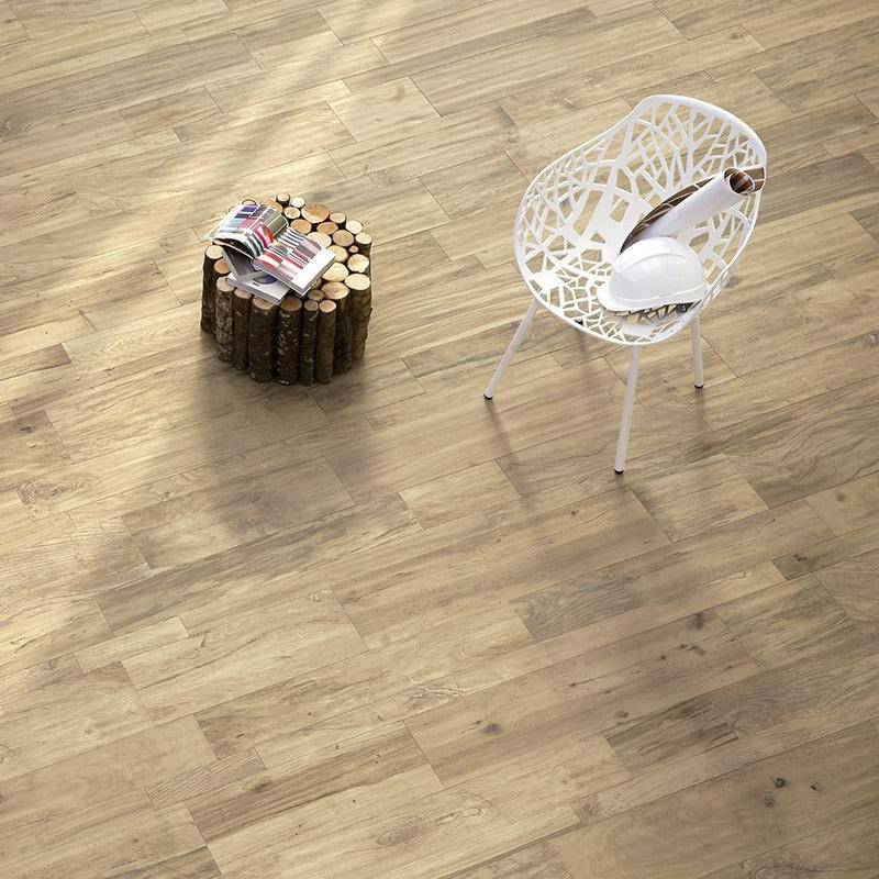 Natural wood-look porcelain tile flooring from the Dead Wood collection by Surface Group with contemporary white chair and wooden log side table in a well-lit room