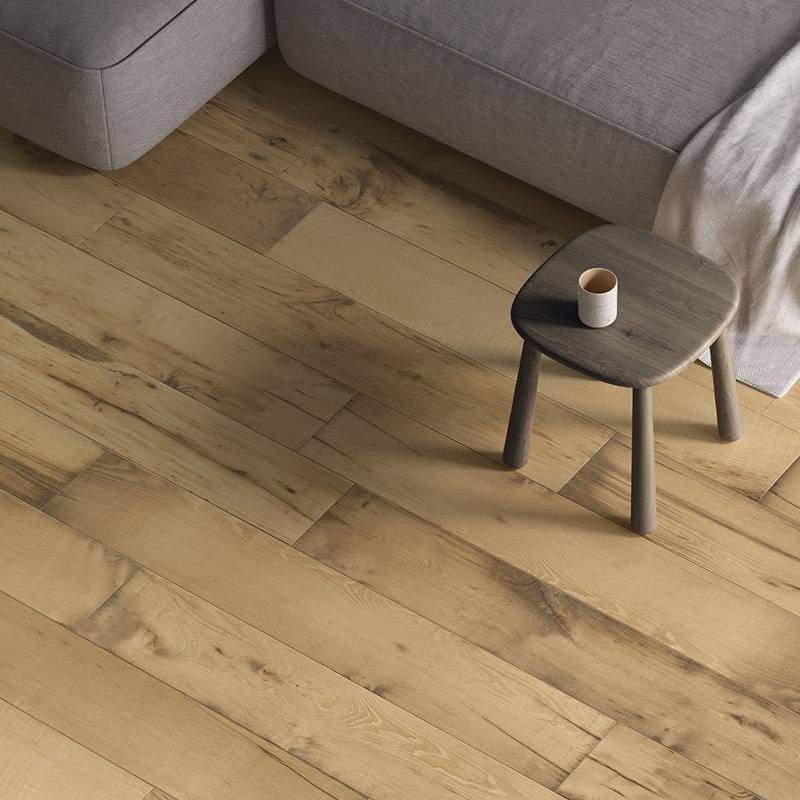 Oak wood-look porcelain tile flooring in a living room setting with a modern stool and sofa corner showing the elegant, natural wooden plank design.