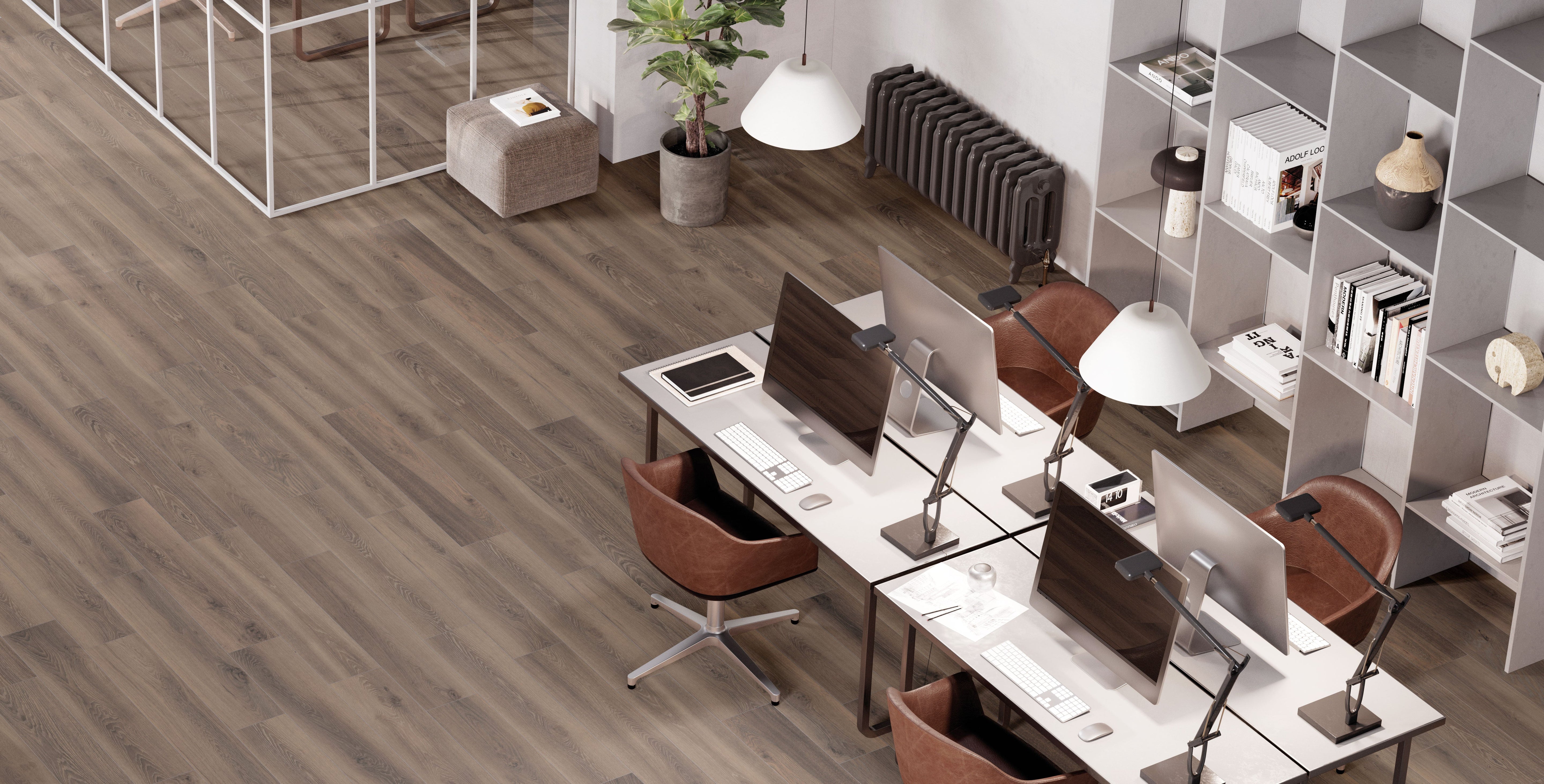 Porcelain tile flooring from the Oxford Collection by Surface Group showcasing a wood-look finish in a modern office setting with stylish furniture and decor.
