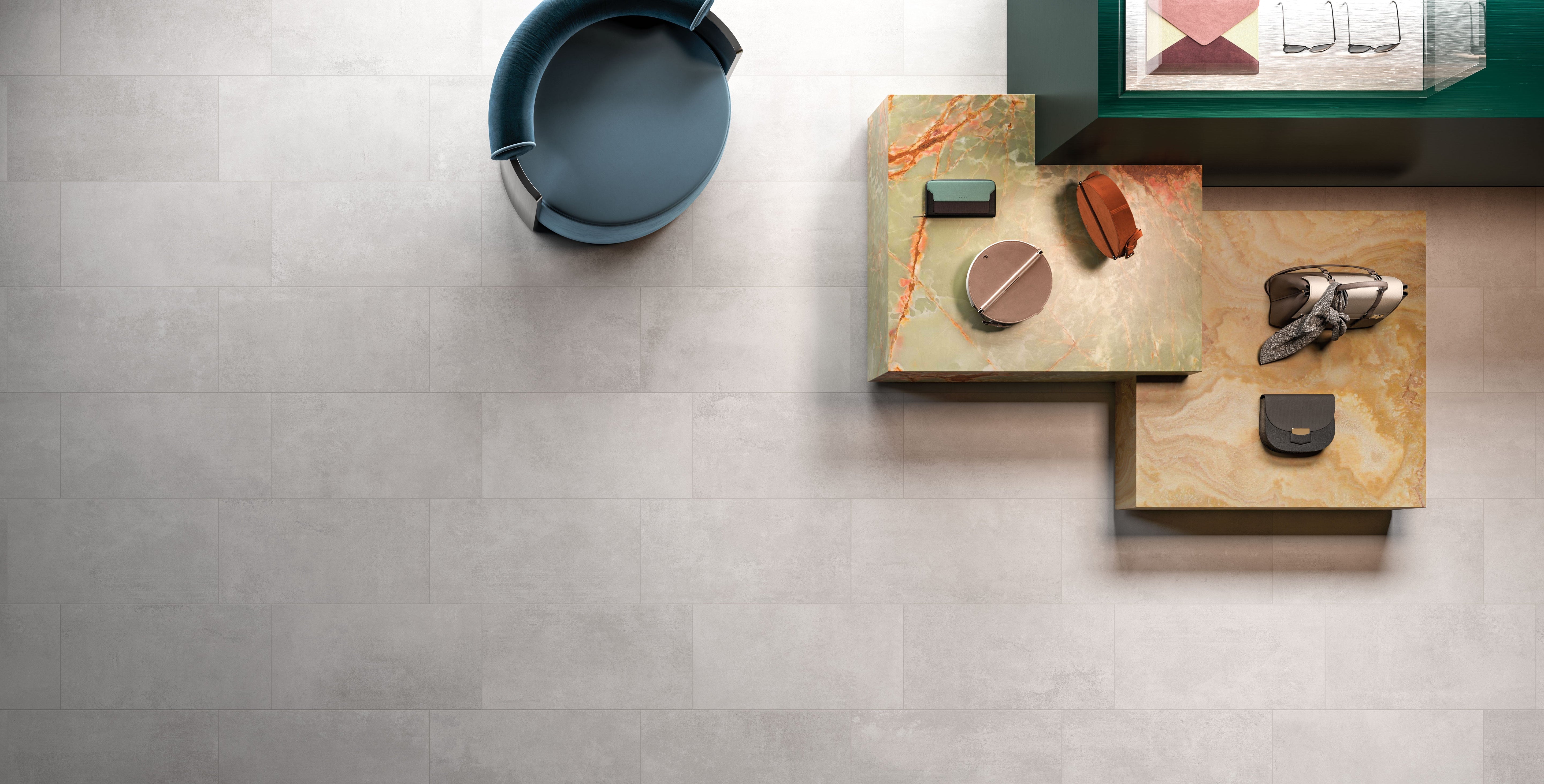 Porcelain tile collection from Surface Group featuring Portland series with neutral tones and modern design, displayed in a stylish interior setting with decorative accents.
