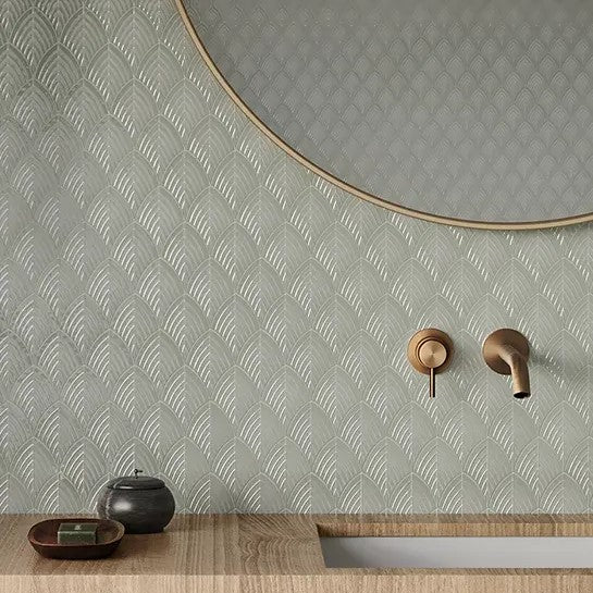 Minimalist bathroom design featuring Anatolia Soho Glazed Ceramic tiles with a subtle, geometric pattern in a calming gray hue, complemented by a contemporary round mirror and elegant bronze fixtures.