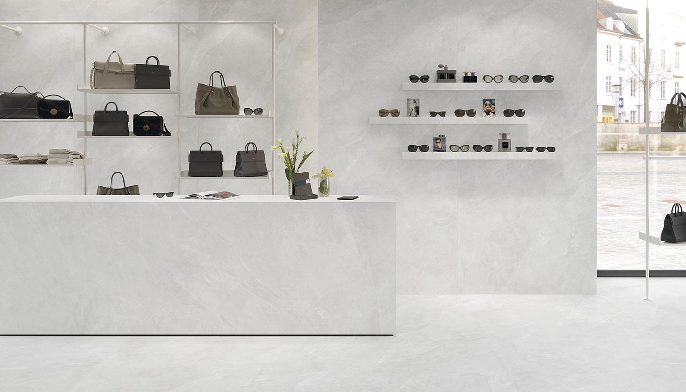 Elegant Emil Ergon Cornerstone Italian porcelain tile collection displayed in a modern interior setting with accessories on shelves and counter.