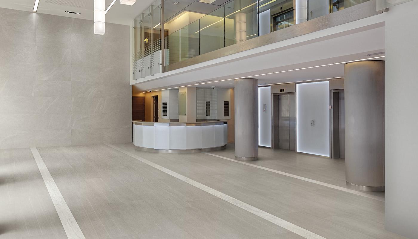 Modern minimalist lobby featuring Emil Ergon Stone Project Italian porcelain tiles with natural stone look, showcasing high-end interior design.