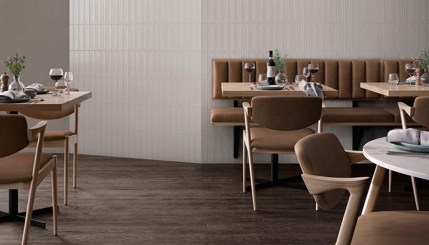 Modern dining area featuring Emil Ergon Tr3nd Italian porcelain tile collection with wood and concrete textures in a high-end interior design