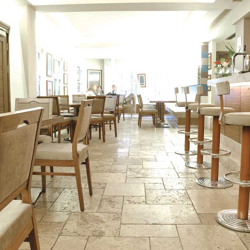 Warm and inviting Travertine Paving Tiles on a restaurant floor with unique textures and patterns, perfect for enhancing the natural beauty and charm of any indoor or outdoor space.