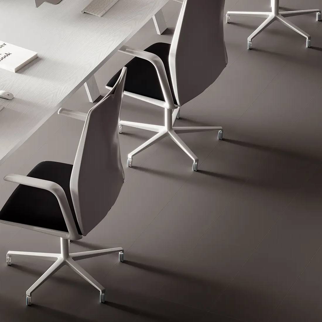A modern office setting with sleek, unglazed porcelain tiles in a dark shade covering the floor, complementing the minimalist aesthetic of the white desk and contemporary swivel chairs with a metal base.
