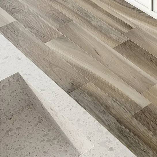 Porcelain tile with a walnut wood look pattern installed in a herringbone design on a floor.