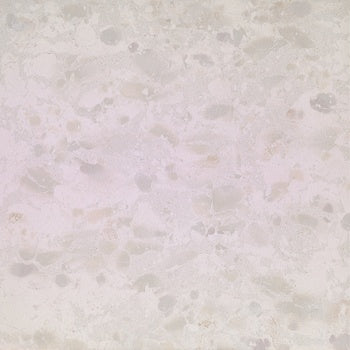 White terrazzo-effect porcelain tile with raw material chips, textured matte finish, and refined industrial elegance.