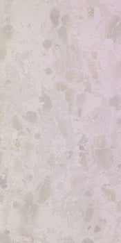 White terrazzo-effect porcelain tile with raw material chips, textured matte finish, and refined industrial elegance.